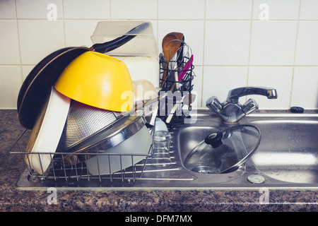 Kitchen utensils drying by sink Stock Photo
