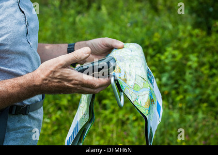 Man holding a GPS receiver and plan in his hand Stock Photo