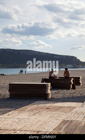 People Relaxing on Poetto Beach at Sundown in Cagliari - Sardinia Stock Photo