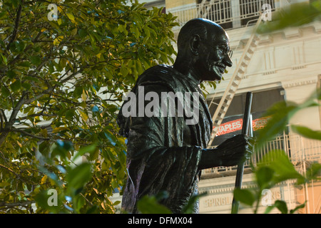 Statue of Mohandas Gandhi (1869–1948) illuminated at night in New York City's Union Square Park sculpted by Kantilal B. Patel Stock Photo