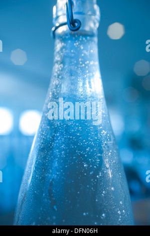 Water condensing on a bottle of cold water in a restaurant. Stock Photo
