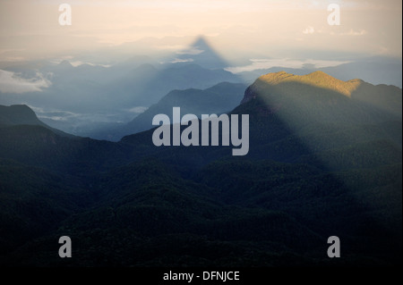 Pyramid shaped shadow at sunrise at Adam's Peak Sri Pada, view of the surrounding mountains, shadow from mountain peak, Mountain Stock Photo