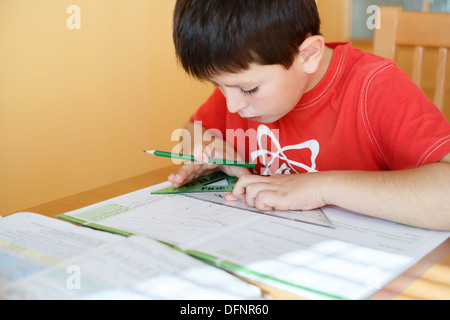boy doing school homework from geometry mathematics in workbook Stock Photo