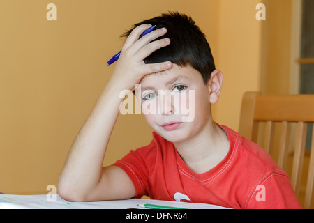boy doing school homework, is tired and bored Stock Photo