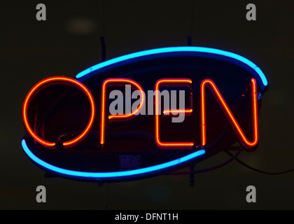 Neon OPEN sign in store window, glowing blue orange, mostly black background Stock Photo