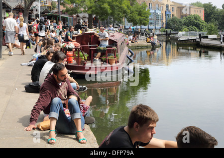 people sitting and watching boats at camden town lock and market in london Stock Photo