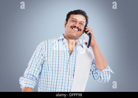 South Indian man talking on a mobile phone and smiling Stock Photo