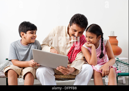 Farmer using a laptop with his children Stock Photo