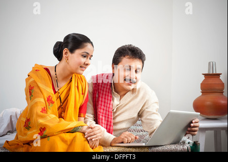 Man using a laptop while his wife looking Stock Photo