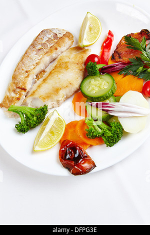 Fresh hake filet with grilled vegetables in a seafood restaurant Stock Photo