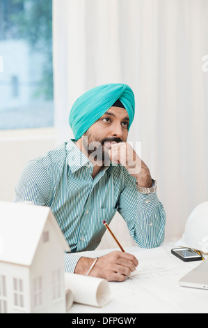 Architect thinking while designing a blueprint Stock Photo