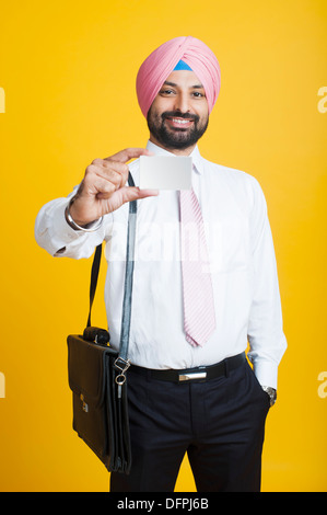 Portrait of a businessman showing a blank business card and smiling Stock Photo