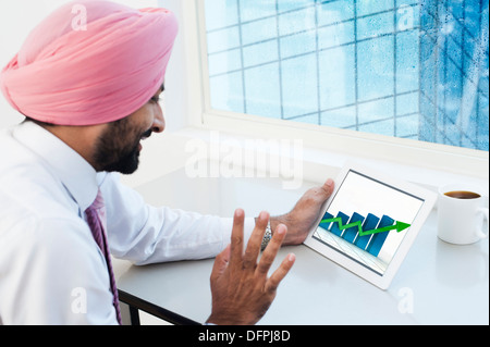 Businessman analyzing graph on a digital tablet Stock Photo