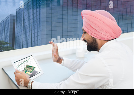 Businessman analyzing graph on a digital tablet Stock Photo