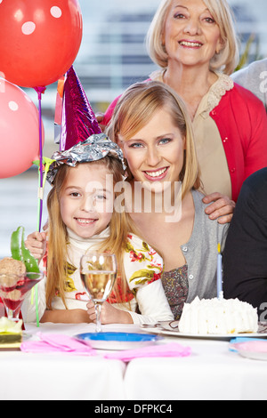 Happy mother and grandmother celebrating their daughter's birthday Stock Photo