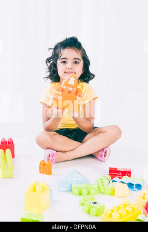 Cute girl playing with plastic blocks Stock Photo - Alamy