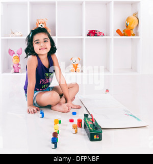 Smiling girl sitting on floor Stock Photo - Alamy