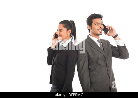 Business executives talking on mobile phones Stock Photo