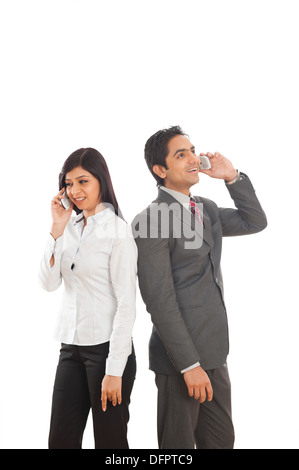 Two business executives talking on mobile phones Stock Photo
