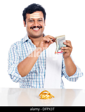 Portrait of a South Indian man counting money and smiling Stock Photo