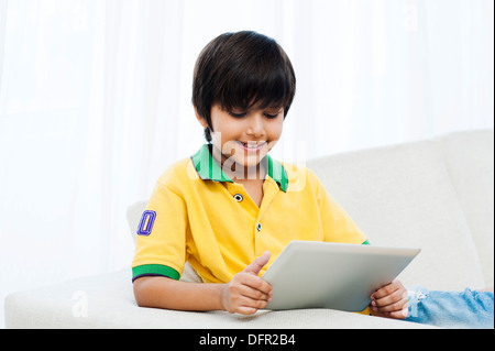 Boy using a digital tablet and smiling Stock Photo