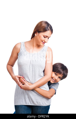 Boy hugging his mother from behind Stock Photo