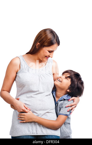 Boy hugging his mother from behind and smiling Stock Photo