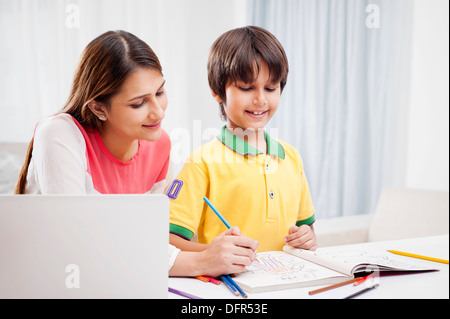 Woman assisting her son in drawing Stock Photo