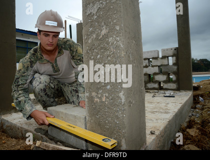 Builder Construction Apprentice Jacob B. Arquette, from Ogdensburg, N.Y., assigned to Naval Mobile Construction Battalion (NMCB) 11, levels a cement block to a vertical column during the manufacturing of a generator enclosure at the Sekondi Naval Medical Stock Photo