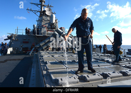 Sonar Technician (Surface) 1st Class Ralph-Keith Tone provides a freshwater wash down of the Mk 41 vertical launch system aboard the Arleigh Burke-class guided-missile destroyer USS Ramage (DDG 61). Ramage, home-ported in Norfolk, Va., is on a scheduled d Stock Photo