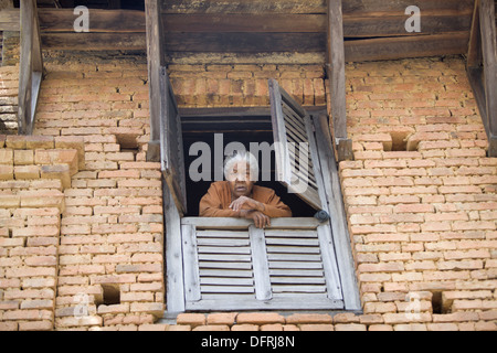 An old Nepali woman looking from the window, Nepal. Stock Photo