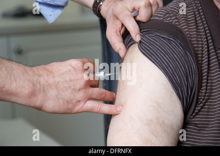 Doctor GP prepares to give the flu jab injection to a patient Doctor GP prepares to give the flu jab injection to a patient