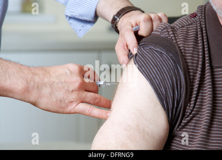 Doctor GP prepares to give the flu jab injection to a patient