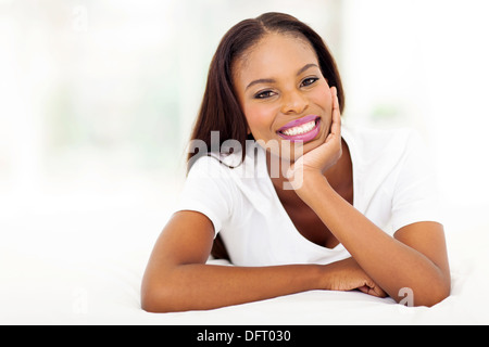 peaceful young African woman lying on bed Stock Photo