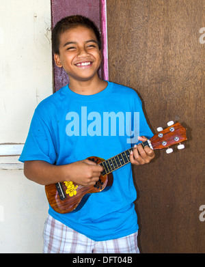 Local boy plays his ukulele. Kosrae, Micronesia Stock Photo