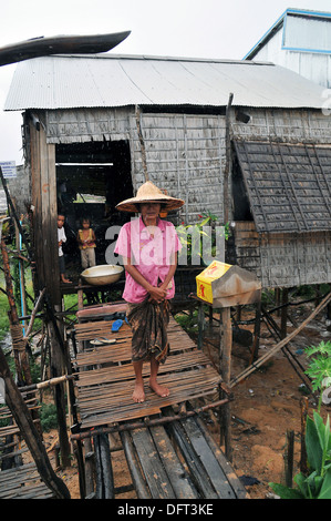 A Cambodian family in the rain at floating village on Tonle Sap Lake near Siem Reap, Cambodia. Stock Photo