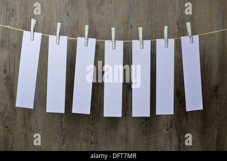 seven sheets of paper hanging on a clothesline Stock Photo
