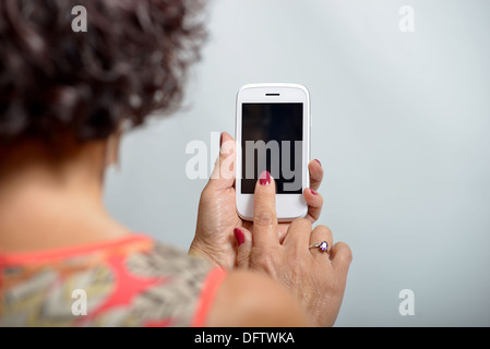 Young woman holding a mobile phone in the hand Stock Photo
