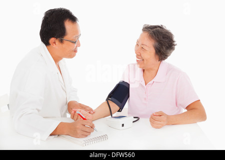 doctor measuring blood pressure of female patient Stock Photo