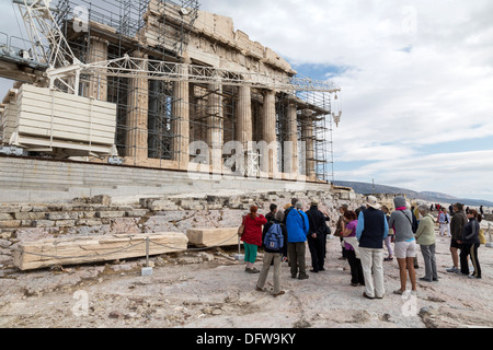 Tourists stand in front of the ancient Temple of Parthenon atop the Acropolis hill on October 4, 2013. Stock Photo