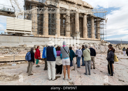 Tourists stand in front of the ancient Temple of Parthenon atop the Acropolis hill on October 4, 2013. Stock Photo