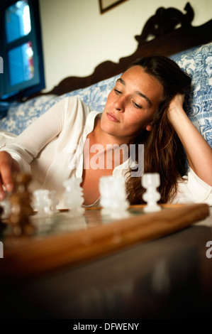 Young brunette playing chess Stock Photo