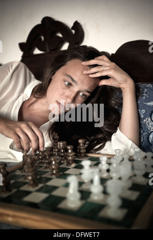 Young brunette playing chess Stock Photo