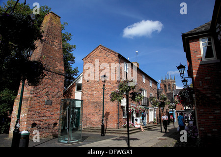 Cocoa Yard, Nantwich, a small shopping arcade with a chimney previously part of a blacksmith’s forge and a millennium clock Stock Photo