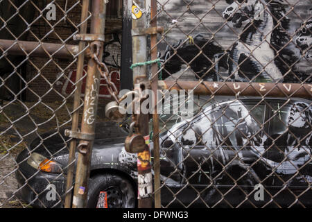 New York City, NY, USA. 09th Oct, 2013. Graffiti enthusiasts flock to a vacant lot in the Lower East Side neighborhood of  New York on Wednesday, October 9, 2013 to see the ninth installment of Banksy's graffiti art. This particular installment is viewed through a chain link fence and a locked fence. © Richard Le Credit:  Richard Levine/Alamy Live News Stock Photo