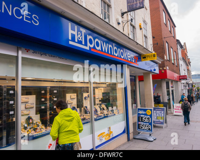 Woman looking in the window of H&T Pawnbrokers in Nottingham at pawned jewelry. Stock Photo