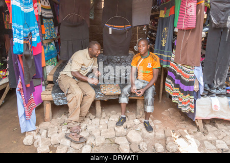 Two local men play draughts (checkers) on a home-made board using soft-drink bottle tops, Maramba Market, Livingstone, Zambia Stock Photo