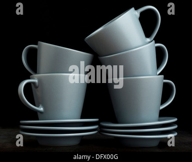 Stack of empty espresso cups and saucers on black background Stock Photo