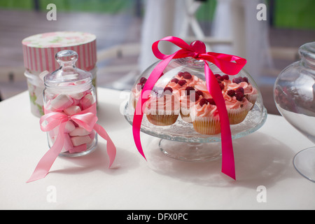 Jug of parisian colorful macarons and tasty cakes on the wedding table Stock Photo