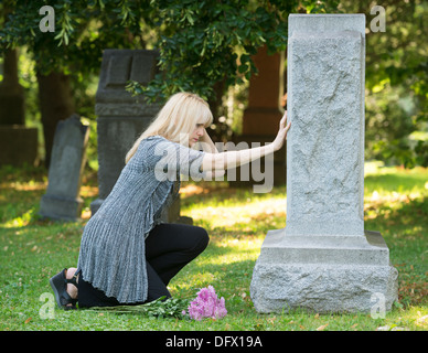 A Grieving Girl Mourns In A Graveyard, Curled Up In Front Of A